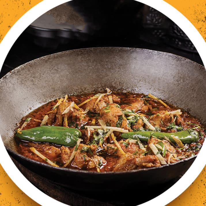 Chicken karahi with green chillies and ginger in an iron wok