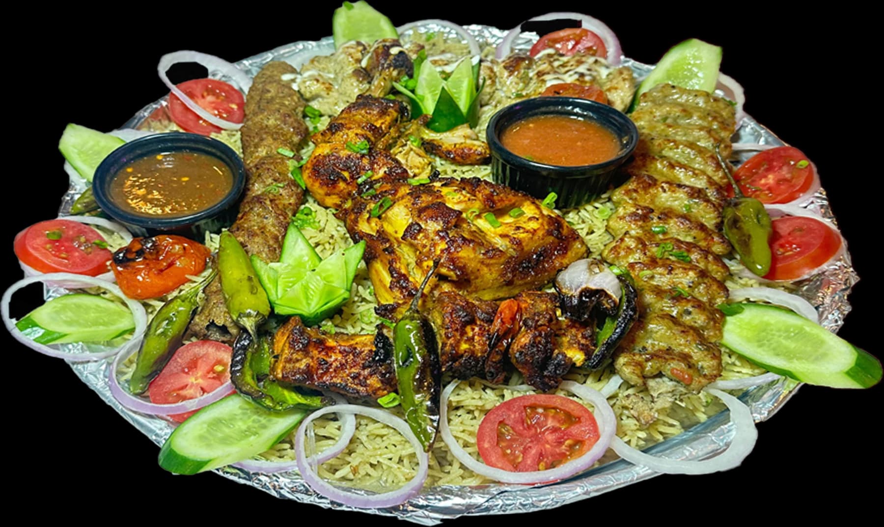 The Dera BBQ platter: chicken tikka, reshmi kabab, beef seekh, malai boti and angara boti over mandi rice with sauces and salad