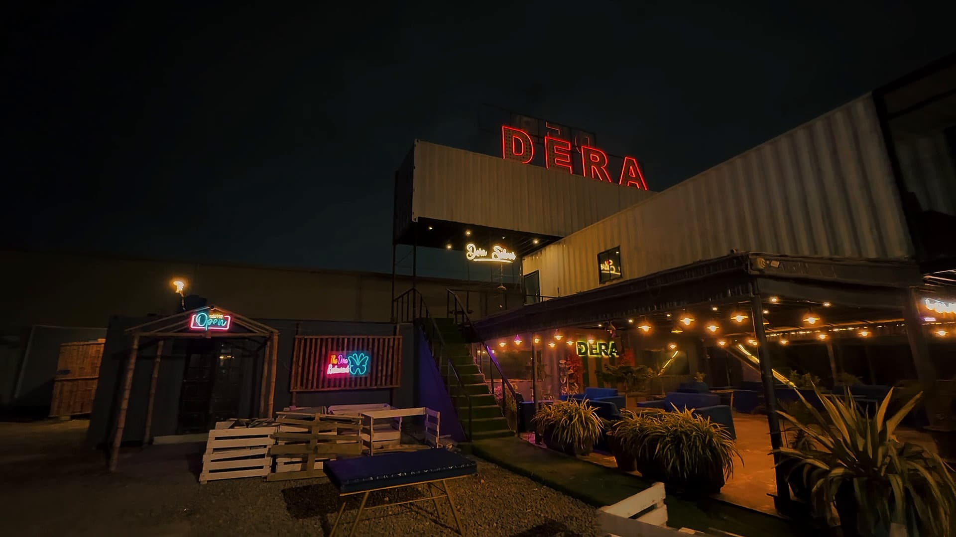 The Dera building lit by string lights under its rooftop sign